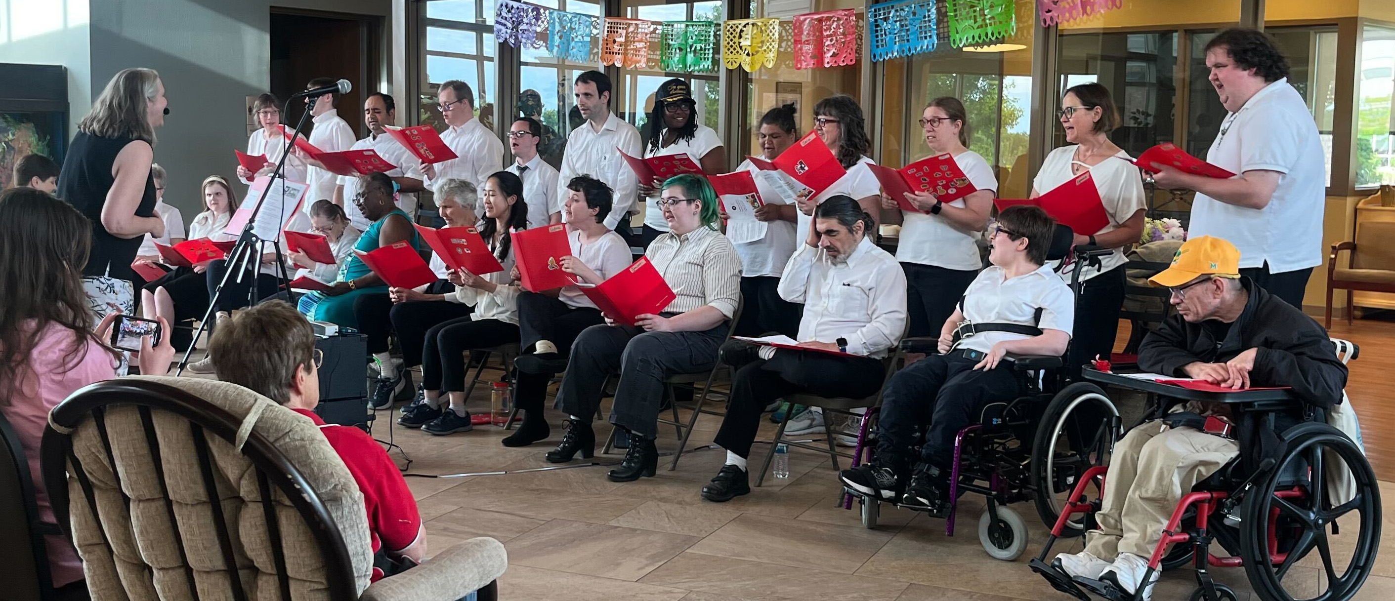 The AFA Madison choir are holding their sheet music while performing their choral concert.